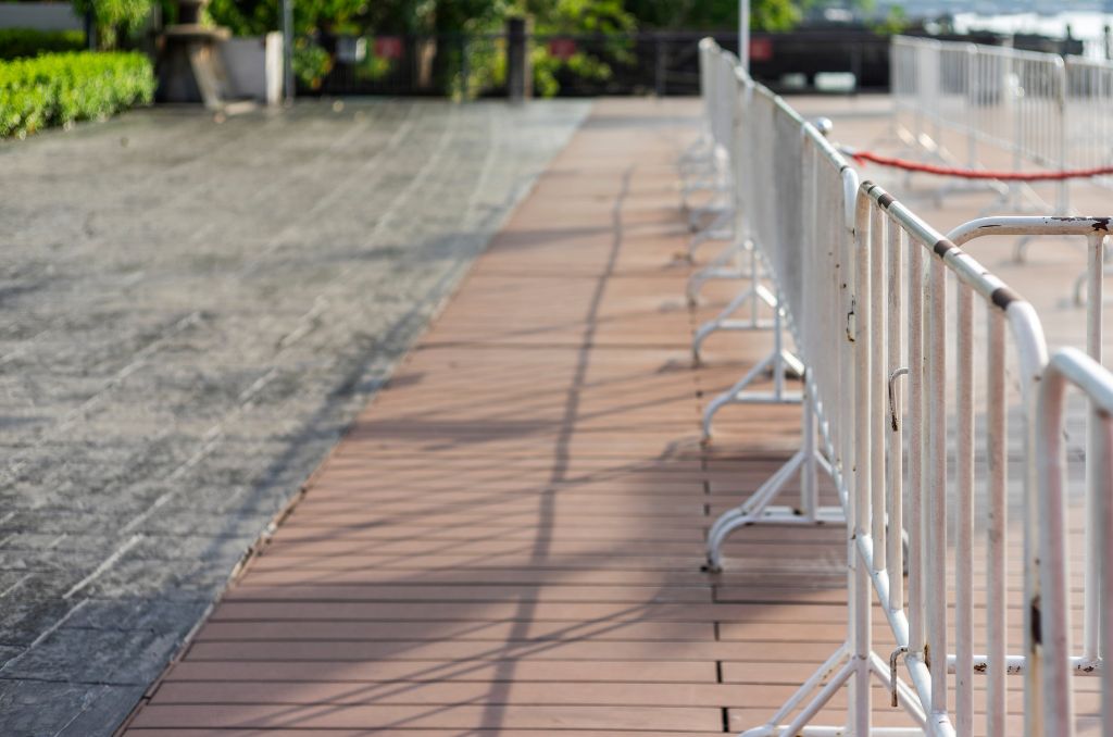 Row of steel interlocking barricades on a brick pathway with blurred background